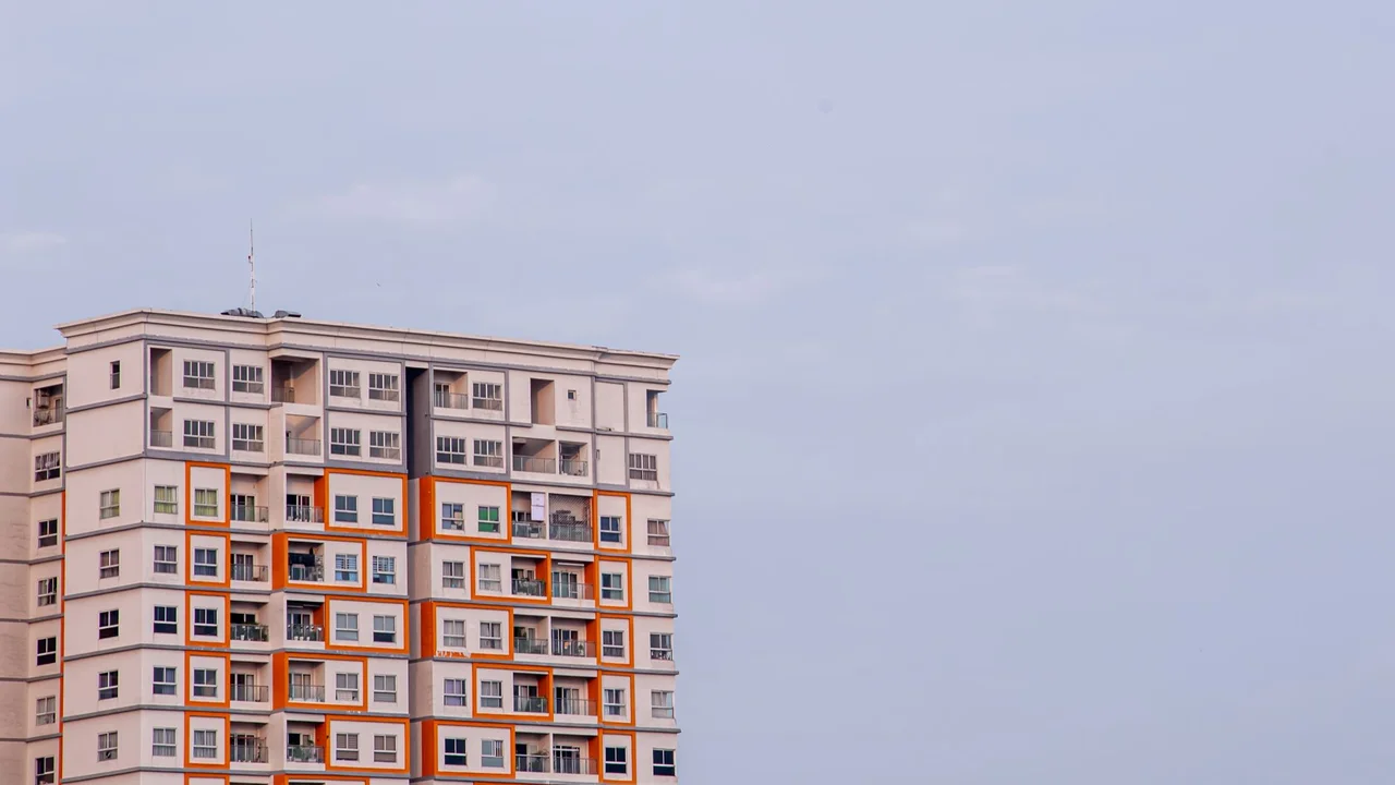 A contemporary apartment building with vibrant facades under a clear sky, showcasing modern urban architecture.