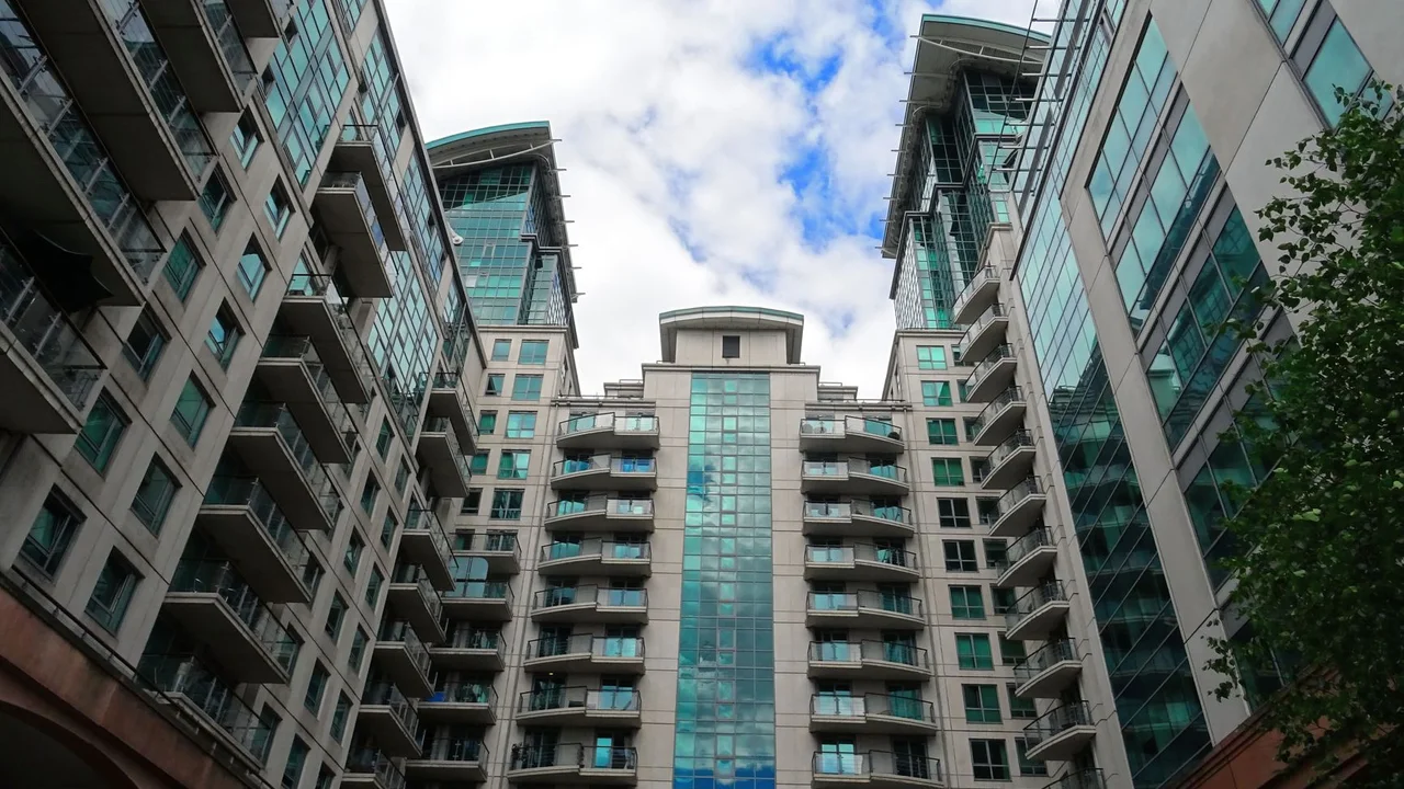Low angle view of modern glass skyscrapers with a blue sky backdrop, highlighting architectural design.