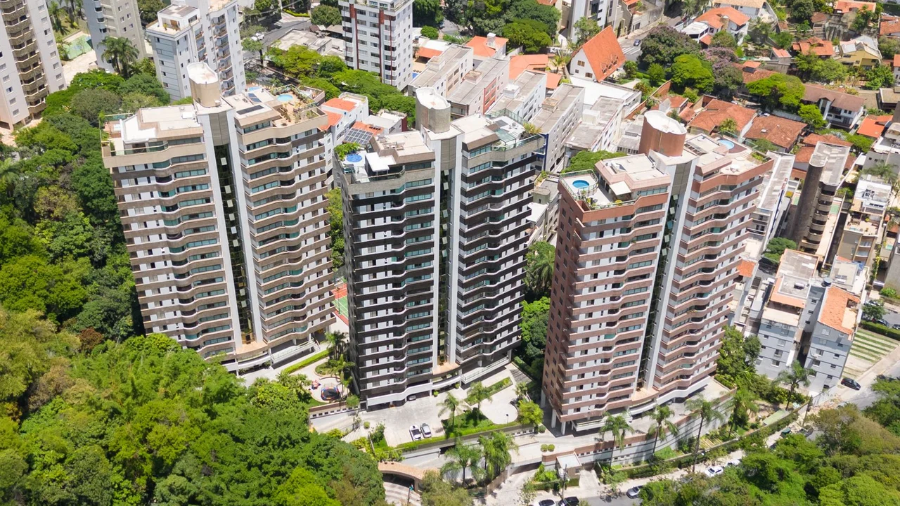 Aerial view of modern apartment buildings surrounded by lush green trees in Belo Horizonte, Brazil.