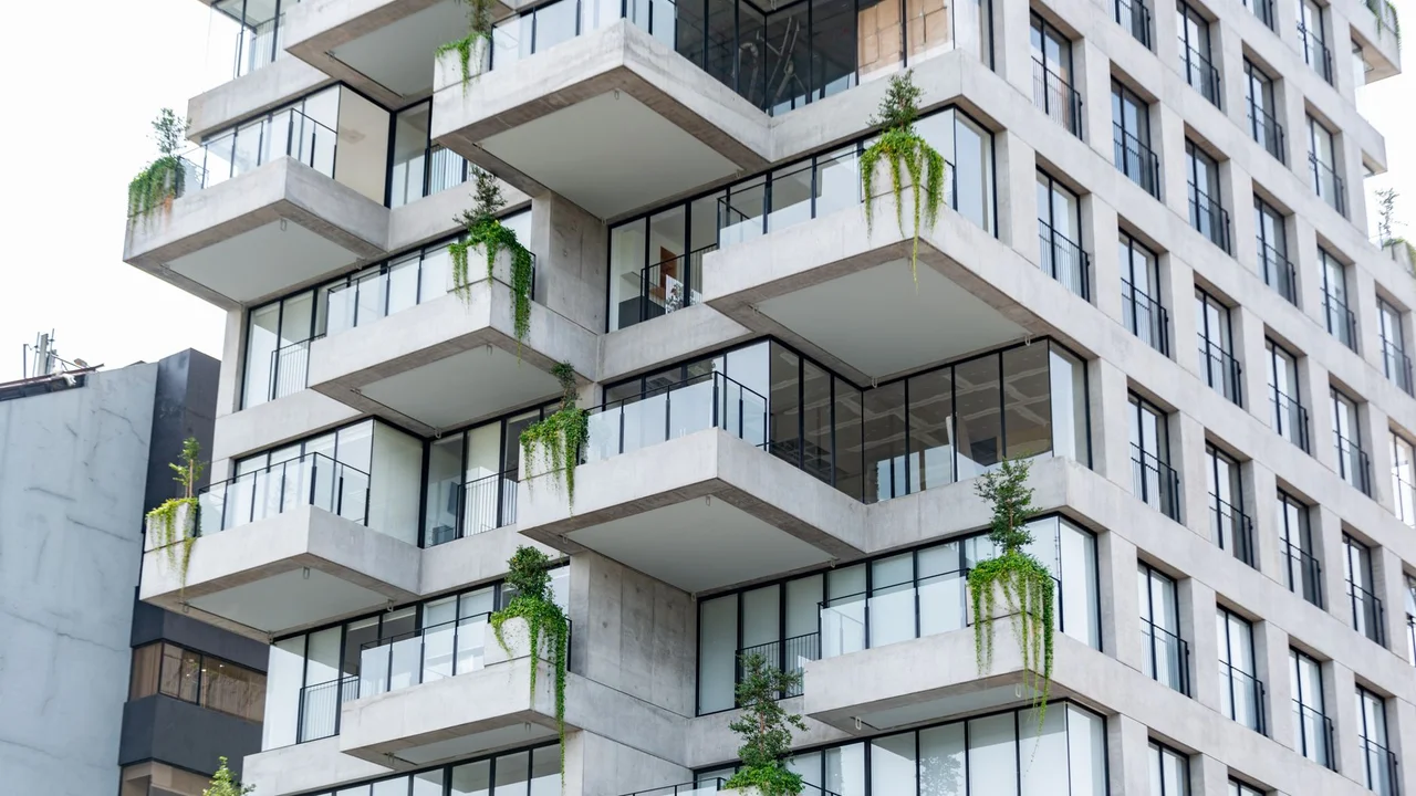 Contemporary residential building featuring geometric design and lush balconies with green plants.