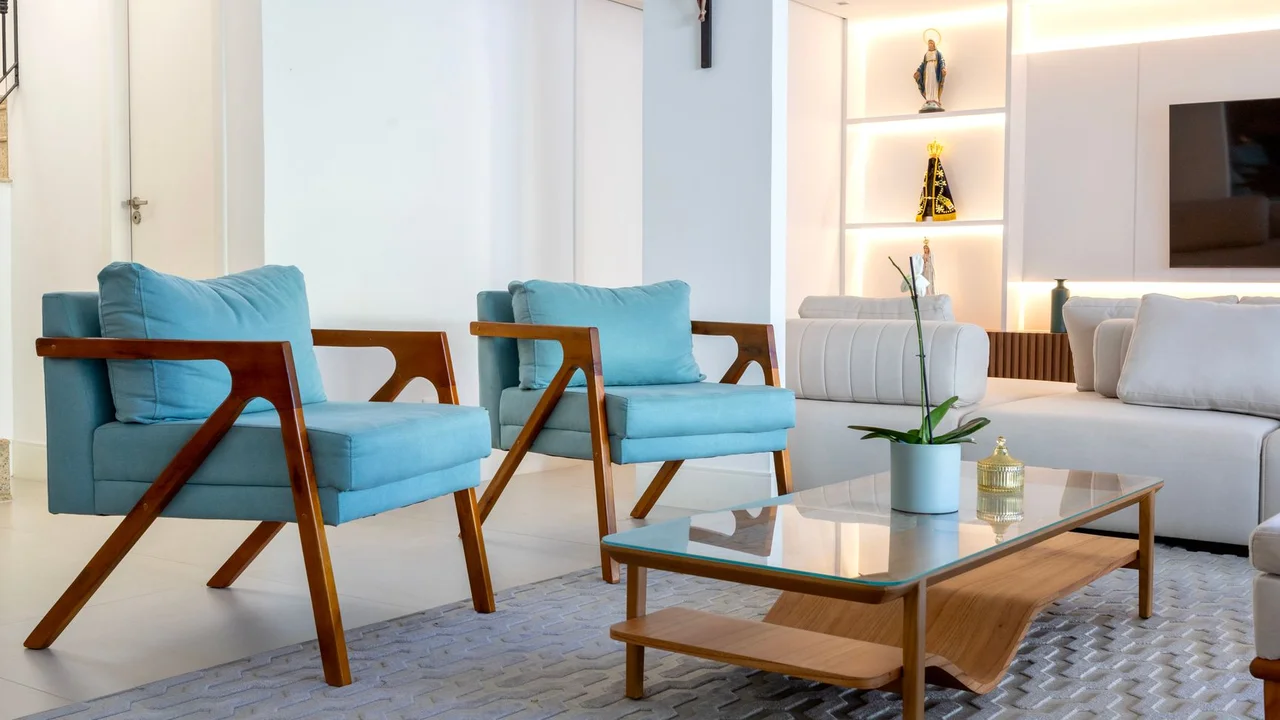 Stylish living room with contemporary blue armchairs, glass table, and decor elements in Salvador, Brazil.