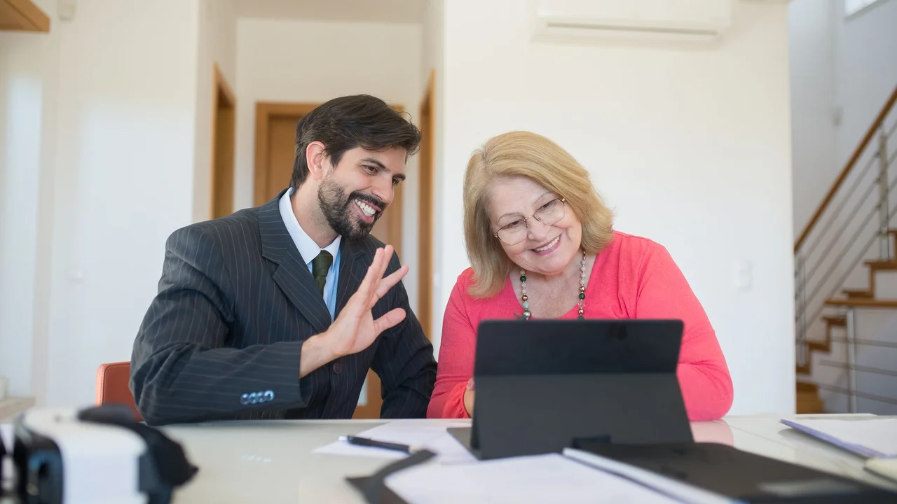 A senior woman and businessman having a discussion in a modern office.