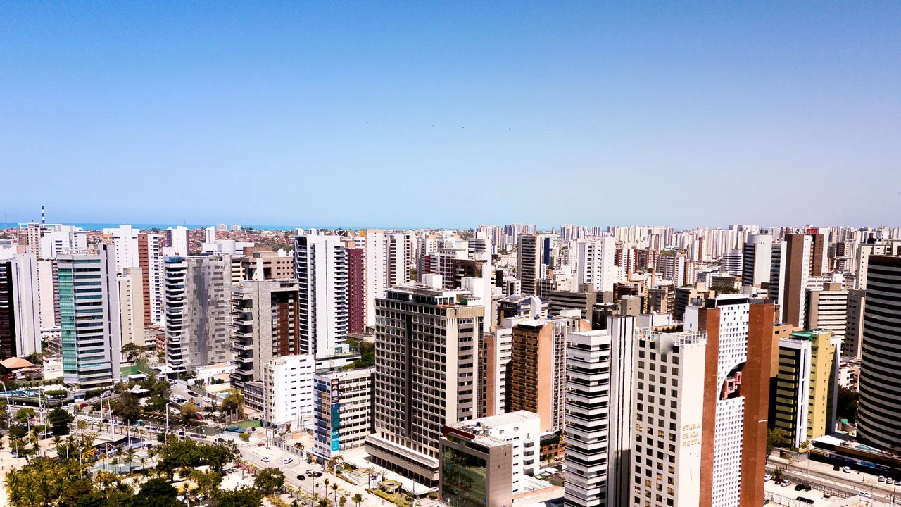 Aerial cityscape of Fortaleza, Brazil, featuring modern skyscrapers under a clear blue sky.