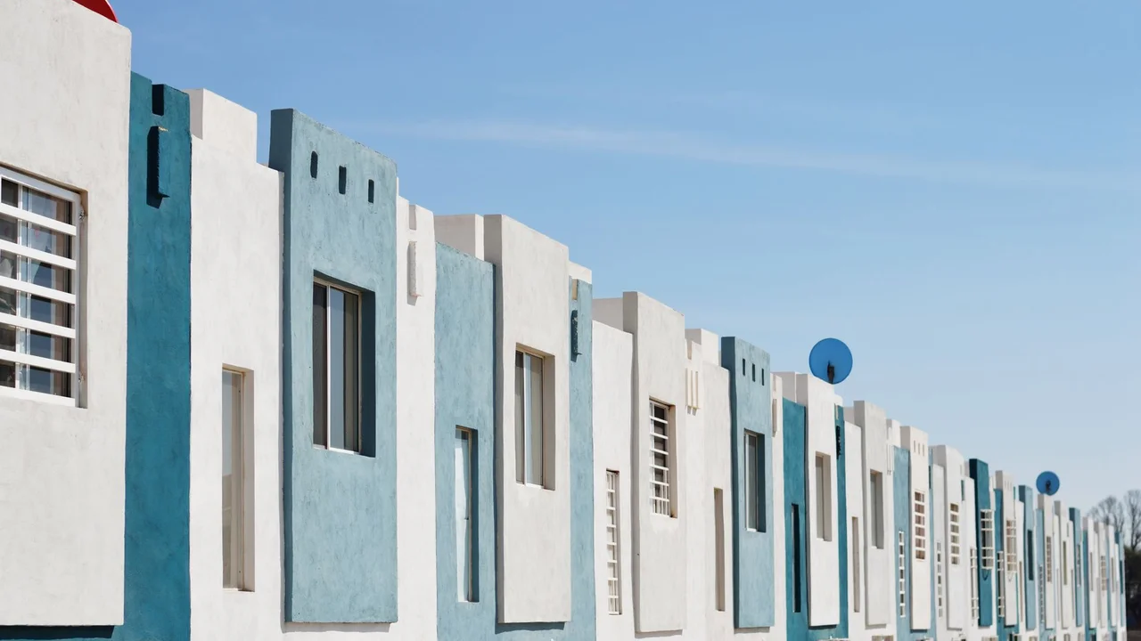 Geometric blue and white facade of a modern apartment building under a clear sky.