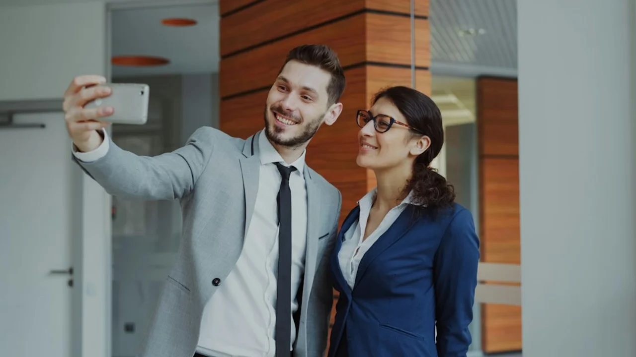 Man and woman taking a selfie in office building
