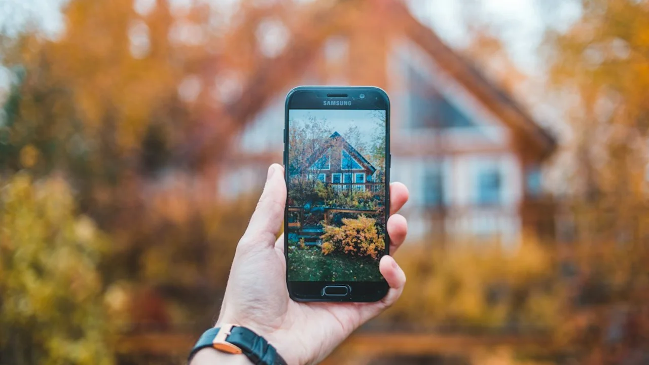 person holding black Samsung smartphone taking a photo of house